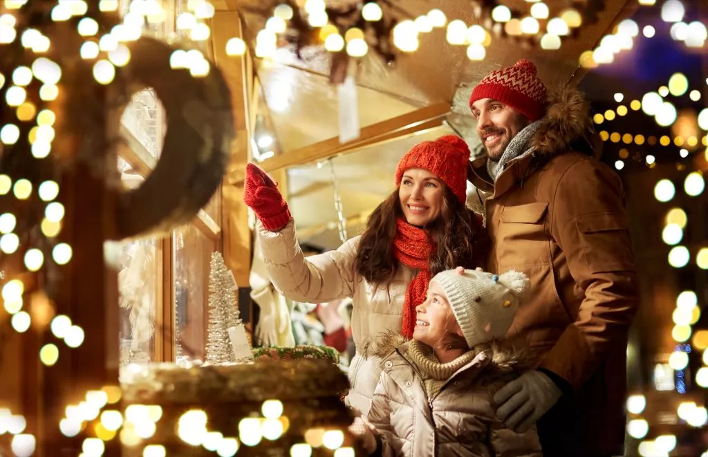 famille, vacances d'hiver et concept de célébration - mère, père et petite fille heureux au marché de Noël sur la place de l'hôtel de ville à tallinn, estonie