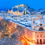 Salzburg, Østerrike: Vinterutsikt over den historiske byen Salzburg med den berømte Festung Hohensalzburg og Salzach-elven opplyst i vakker skumring i den vakre juletiden i Winte.
