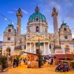 Festlig bybilde - utsikt over julemarkedet på Karlsplatz (Karlstorget) og Karlskirche (Karlskirken) i Wien, Østerrike.